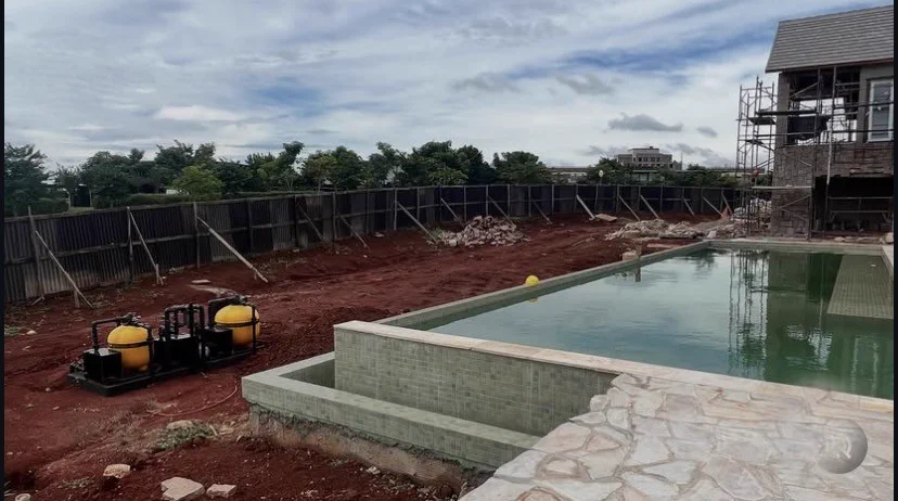 Piscina recém-construída, com terreno em obra e sem paisagismo ao redor