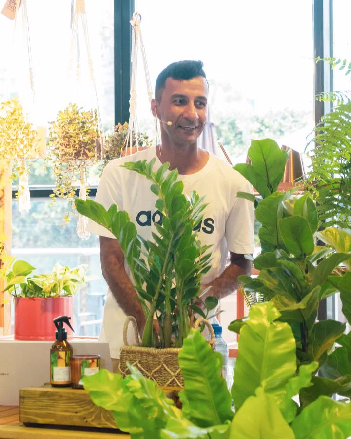 Danilo Barros sorrindo, cercado de plantas em um de seus projetos
